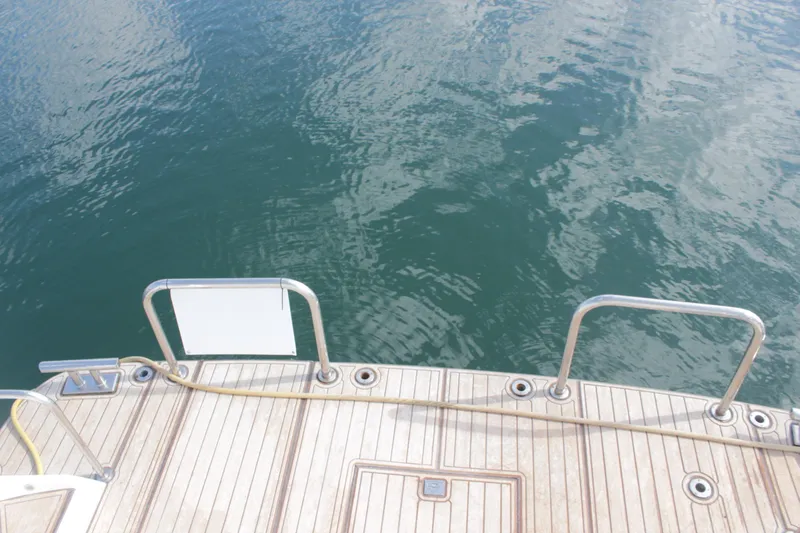 Slide: The Image of Stern view of 1999 Horizon 70 Motor Yacht with teak deck and water backdrop. - 72