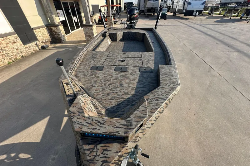 Slide: The Image of 2026 Xpress X18DB boat with camouflage design, parked outdoors near a building. - 10