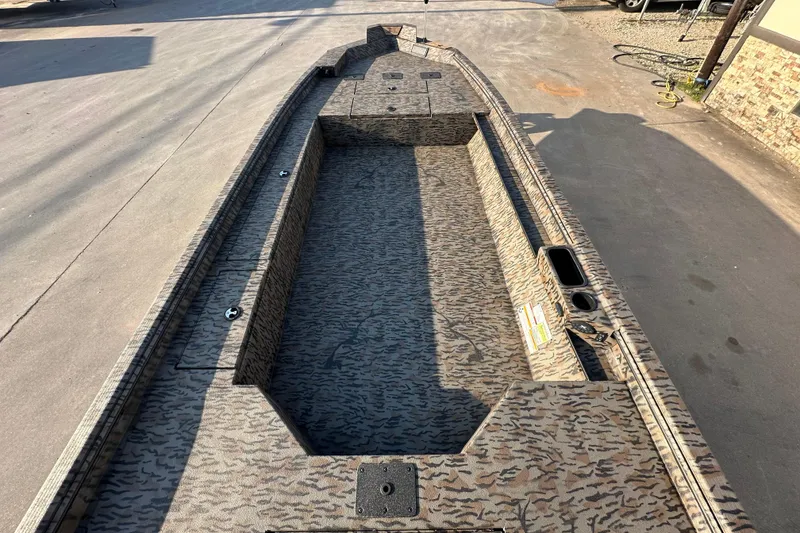 Slide: The Image of 2026 Xpress X18DB boat interior with camouflage design, parked on pavement. - 13