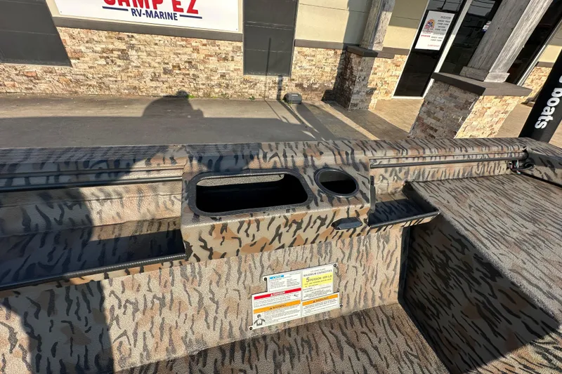 Slide: The Image of 2026 Xpress X18DB boat interior with camouflage design and cup holders. - 19