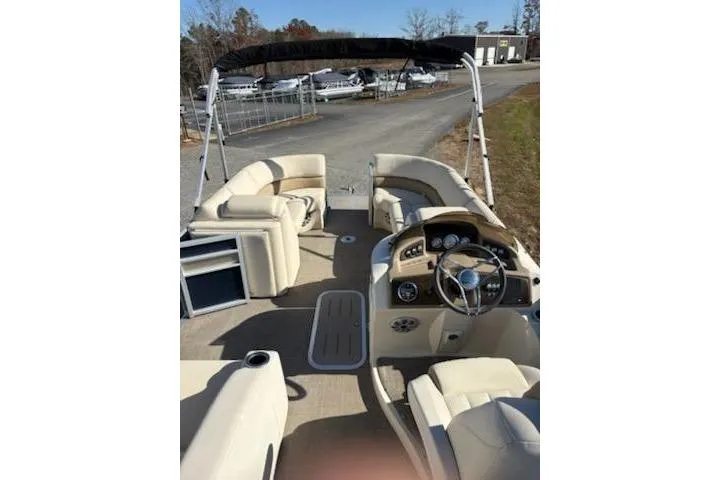Slide: The Image of 2016 Bennington 2375 GCW pontoon boat interior with beige seating and steering console. - 9