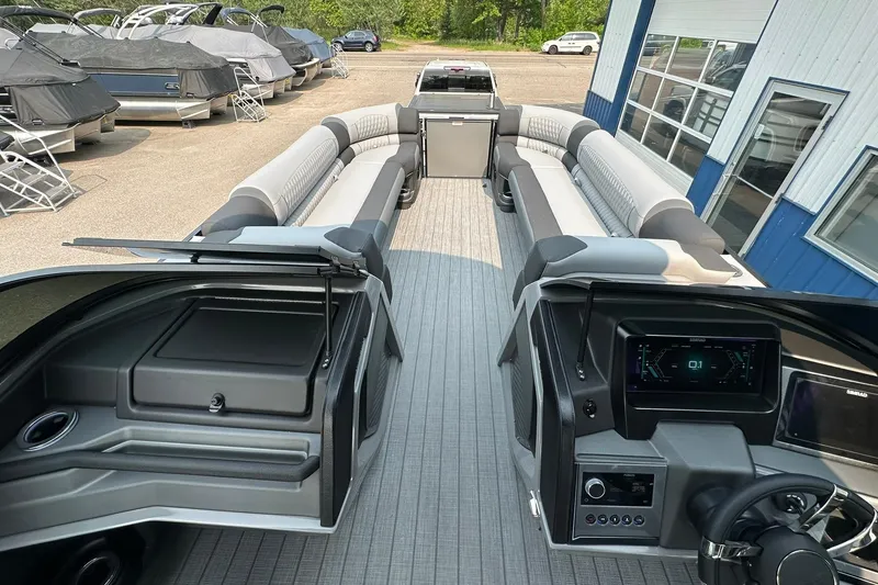 Slide: The Image of 2025 Avalon Excalibur LTD Quad Lounge Windshield boat interior with modern dashboard and seating. - 24