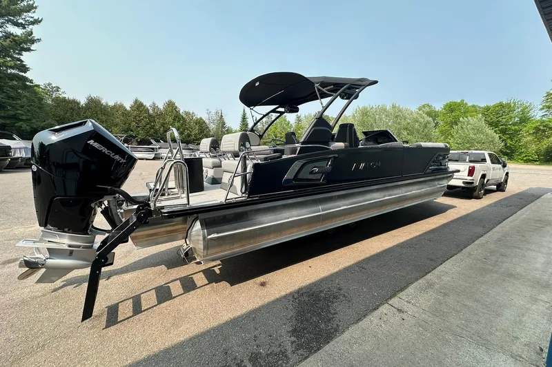 Slide: The Image of 2025 Avalon Excalibur LTD Quad Lounge Windshield pontoon boat with Mercury engine, parked outdoors. - 5