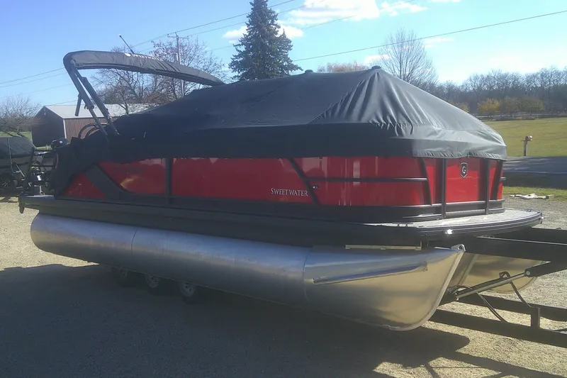 Slide: The Image of 2025 Godfrey Sweetwater 2086 Cruise Special Edition pontoon boat with cover, parked outdoors. - 16