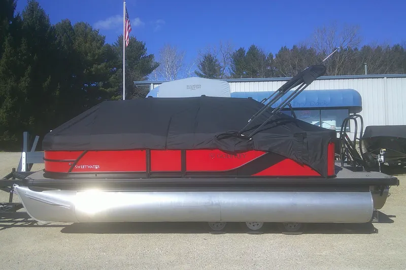 Slide: The Image of 2025 Godfrey Sweetwater 2086 Cruise Special Edition pontoon boat with cover, parked outdoors. - 17
