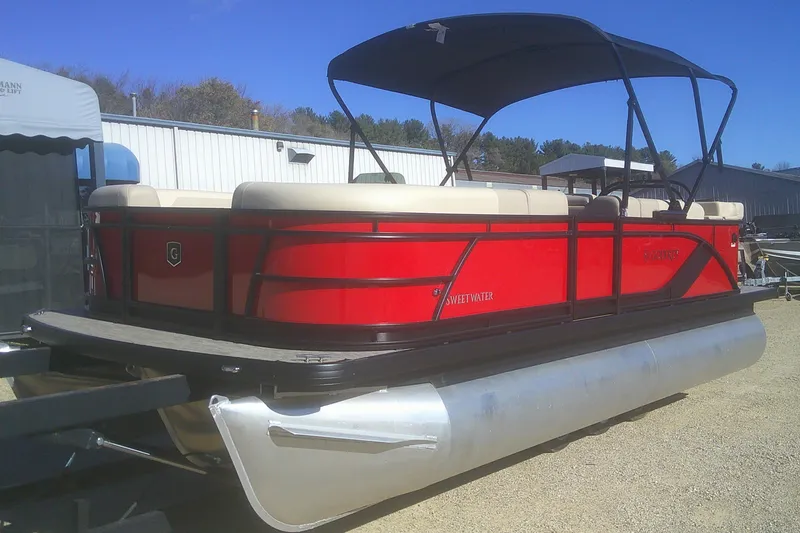 Slide: The Image of 2025 Godfrey Sweetwater 2086 Cruise Special Edition pontoon boat, red with canopy, parked outdoors. - 4