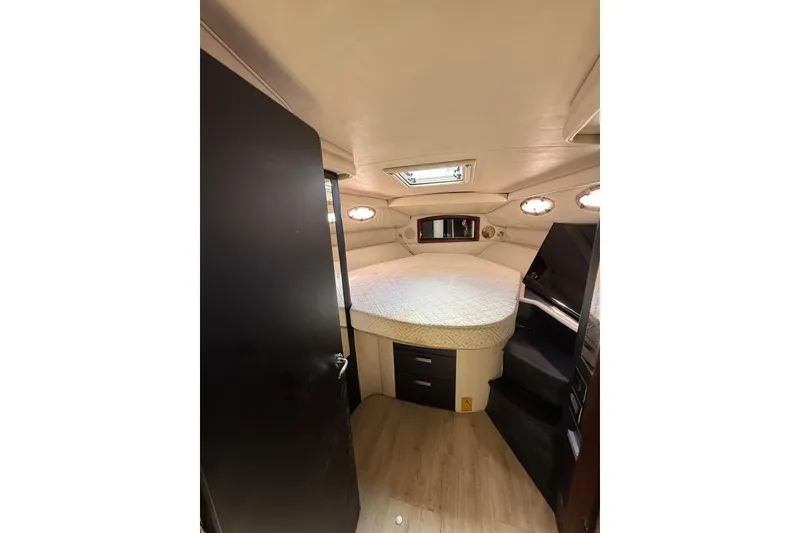 Slide: The Image of 1998 Sea Ray 420 Sundancer cabin interior with bed, storage, and portholes. - 12