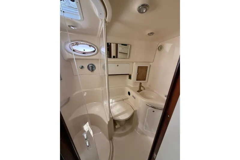Slide: The Image of 1998 Sea Ray 420 Sundancer bathroom with shower, sink, and porthole window. - 5
