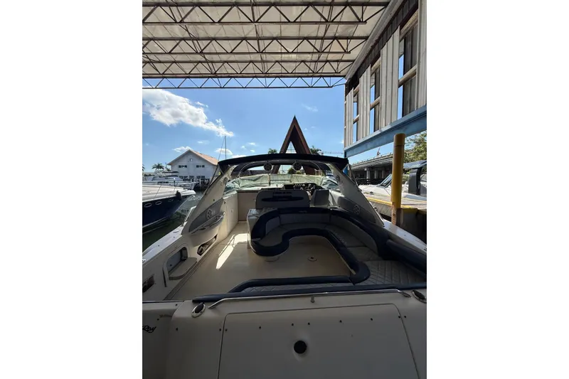 Slide: The Image of 1998 Sea Ray 420 Sundancer docked under a canopy, showcasing spacious deck and seating. - 8