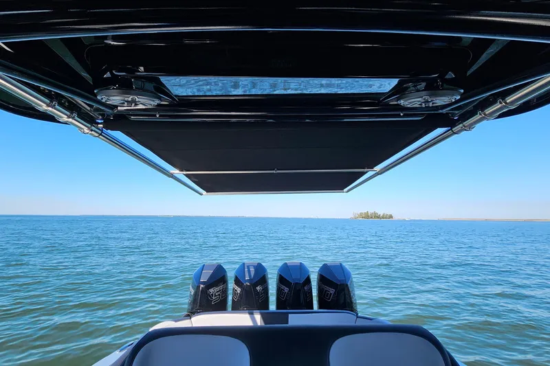 Slide: The Image of 2025 Nor-Tech 390 Sport Center Console on open water, featuring four powerful engines. - 14