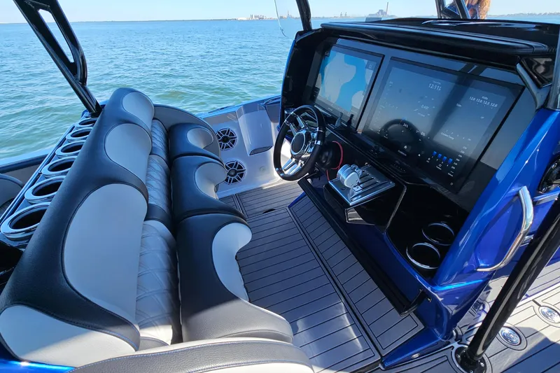 Slide: The Image of 2025 Nor-Tech 390 Sport Center Console with modern dashboard and seating on open water. - 23