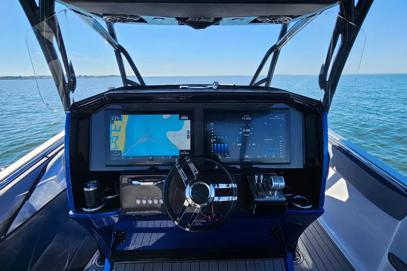 Slide: The Image of 2025 Nor-Tech 390 Sport Center Console dashboard with navigation screens on open water. - 25
