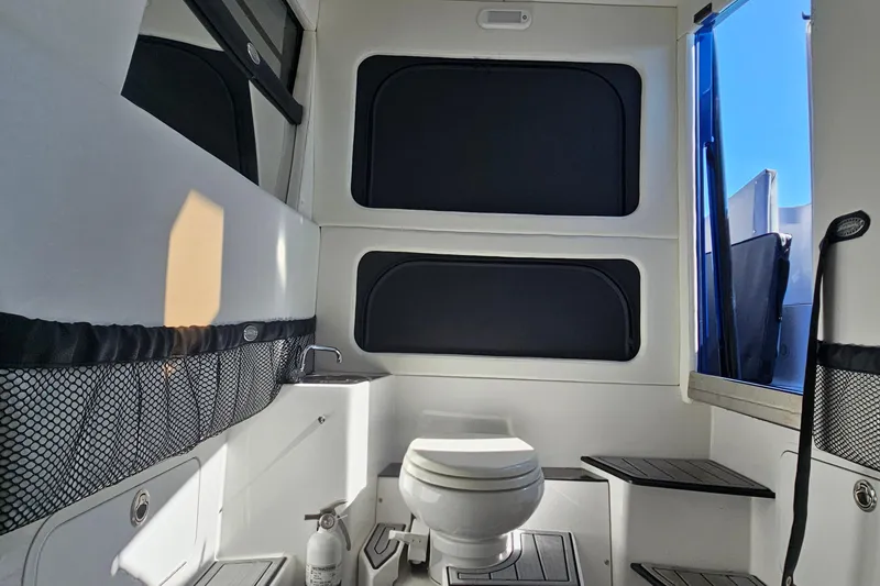 Slide: The Image of Interior of 2025 Nor-Tech 390 Sport Center Console boat, featuring a compact bathroom. - 34