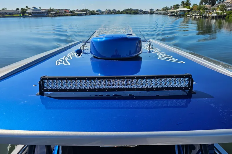 Slide: The Image of 2025 Nor-Tech 390 Sport Center Console on calm water, featuring a sleek blue design. - 36