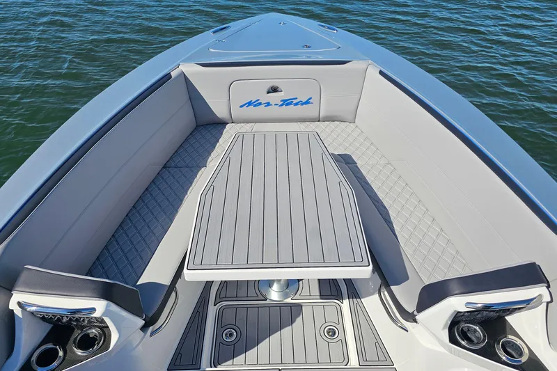 Slide: The Image of 2025 Nor-Tech 390 Sport Center Console boat interior with sleek seating and table. - 40