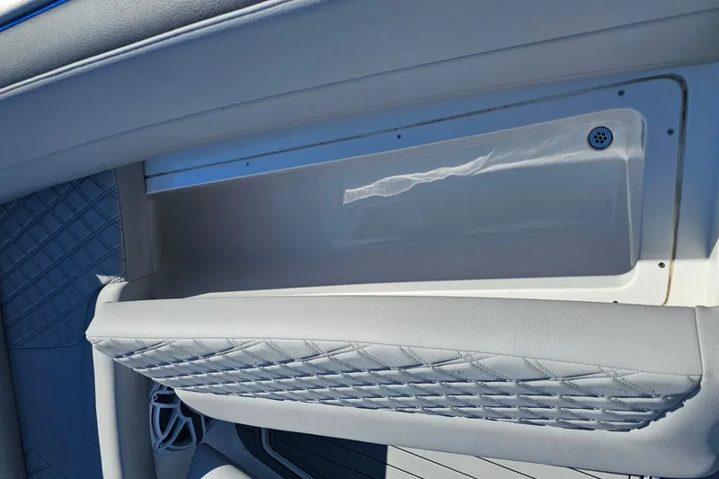 Slide: The Image of 2025 Nor-Tech 390 Sport Center Console interior detail with quilted upholstery and storage compartment. - 48