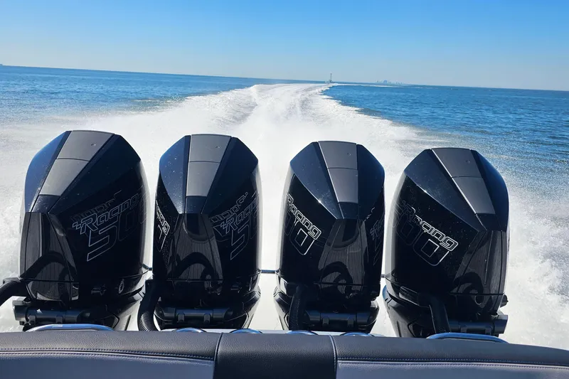 Slide: The Image of 2025 Nor-Tech 390 Sport Center Console with four powerful outboard engines on open water. - 50