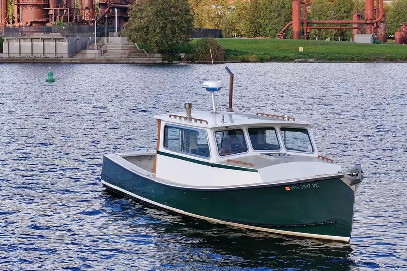 Slide: The Image of 1984 Martin Yachts Lobster Boat on water near industrial backdrop. - 11