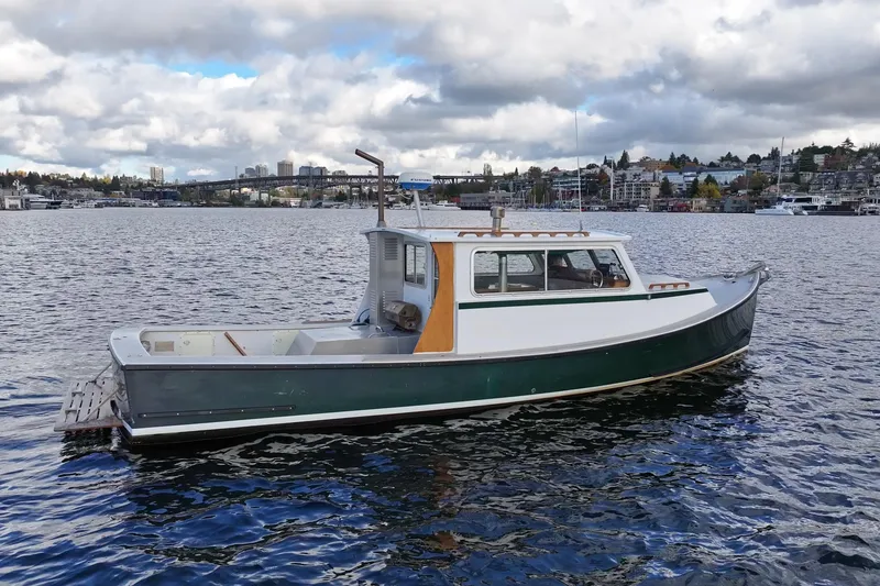 Slide: The Image of 1984 Martin Yachts Lobster Boat on calm water with cityscape background. - 13