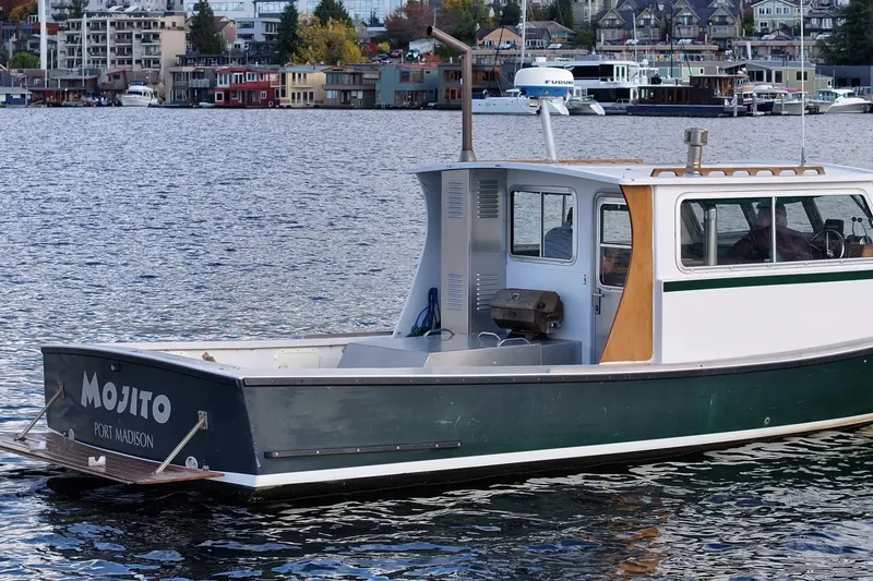 Slide: The Image of 1984 Martin Yachts Lobster Boat "Mojito" on water, Port Madison backdrop. - 15