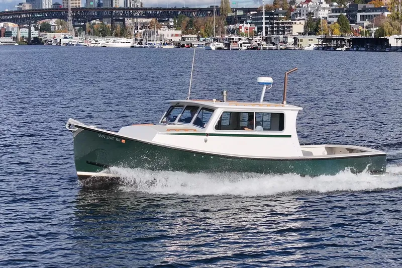 Slide: The Image of 1984 Martin Yachts Lobster Boat cruising on a scenic waterfront with city skyline backdrop. - 2