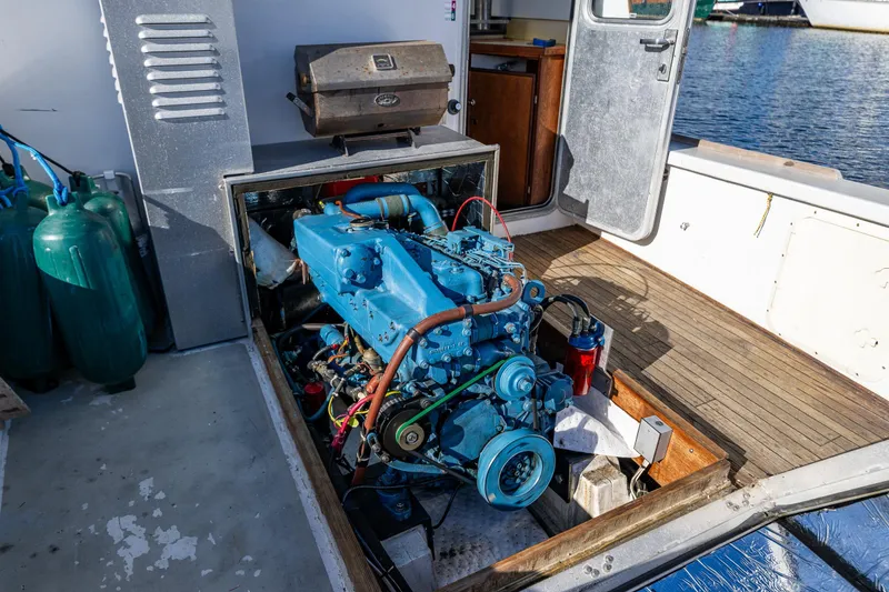 Slide: The Image of Engine compartment of a 1984 Martin Yachts Lobster Boat, featuring a blue marine engine. - 20