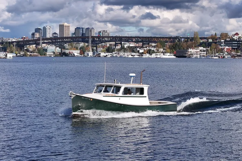 Slide: The Image of 1984 Martin Yachts Lobster Boat cruising on a scenic urban waterway with city skyline backdrop. - 8