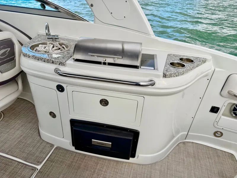 Slide: The Image of Crownline 285 XS 2023 boat kitchen with grill and sink. - 11