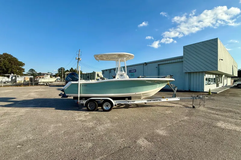 The Image of 2020 Tidewater 210 LXF boat on trailer, parked outside a building under a clear blue sky. - 0