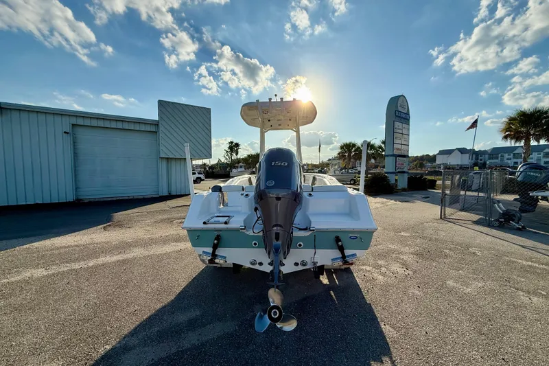 Slide: The Image of 2020 Tidewater 210 LXF boat with outboard motor in sunny marina setting. - 2