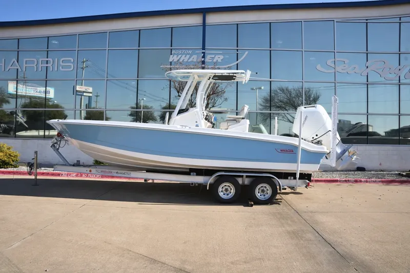 Slide: The Image of A 2026 Boston Whaler 250 Dauntless on a trailer in front of a building with large windows. - 32