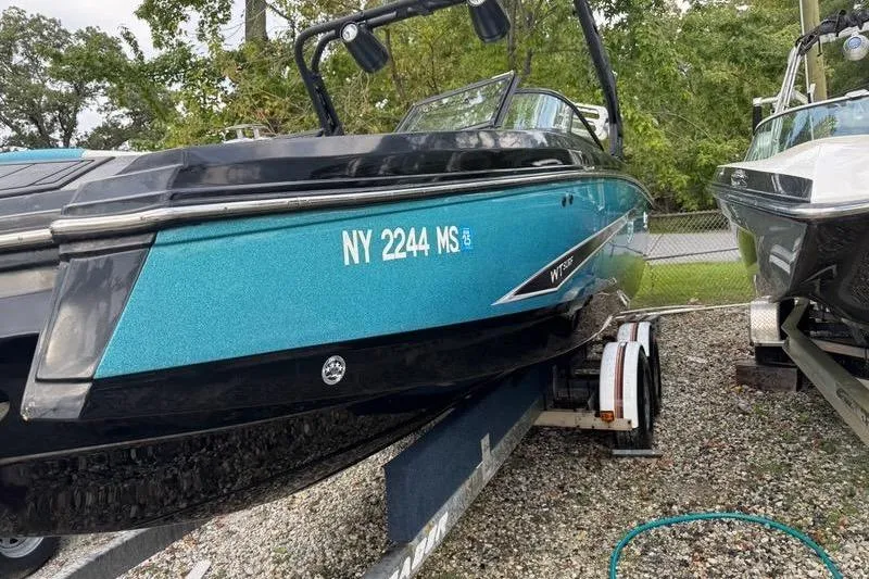 Slide: The Image of 2021 Heyday WTSurf boat in blue, parked on a trailer, side view. - 11