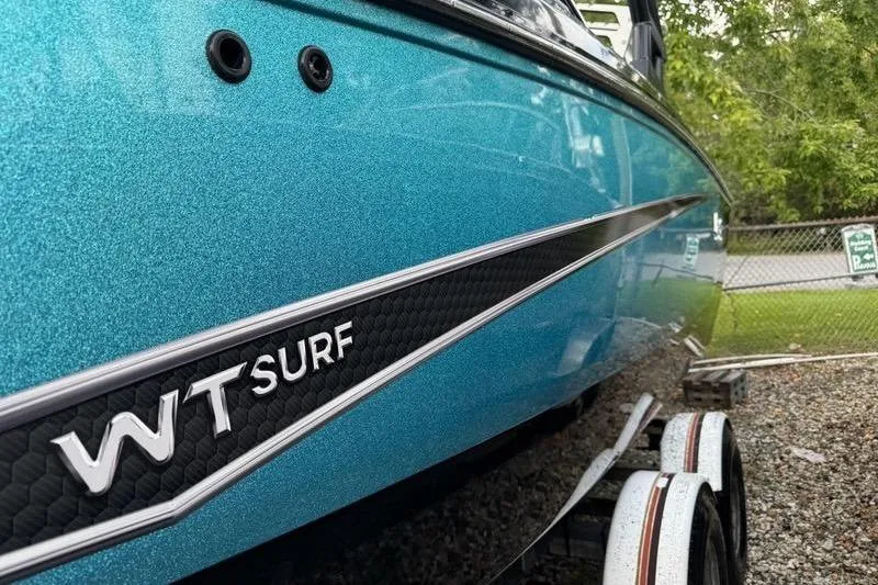 Slide: The Image of 2021 Heyday WTSurf boat in vibrant blue, parked on a trailer. - 12