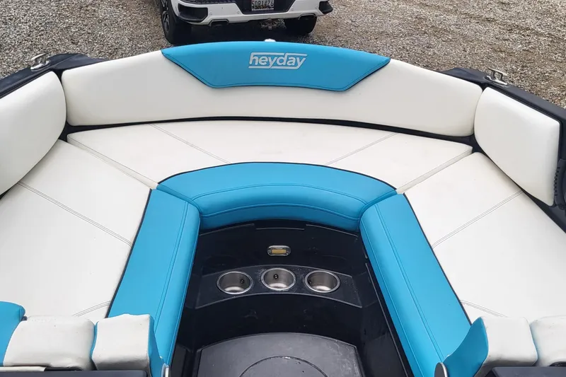 Slide: The Image of 2021 Heyday WTSurf boat interior with blue and white seating and cup holders. - 14