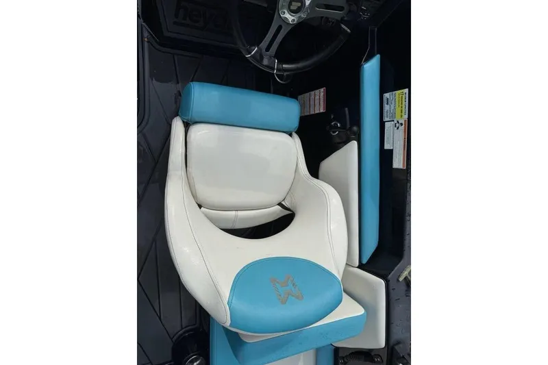 Slide: The Image of 2021 Heyday WTSurf boat seat, white and blue design, steering wheel visible. - 6
