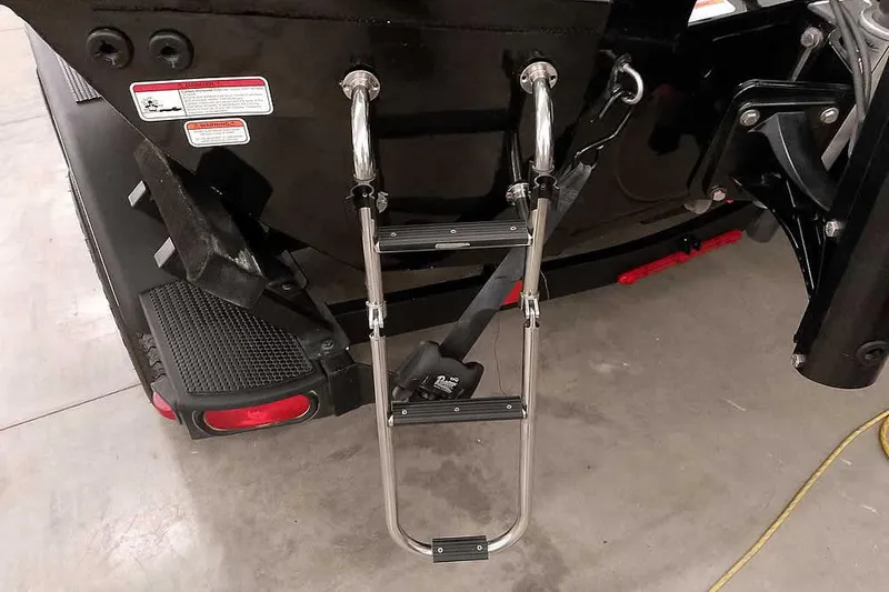 Slide: The Image of 2023 Ranger RT198P boat ladder and rear details in a garage setting. - 13
