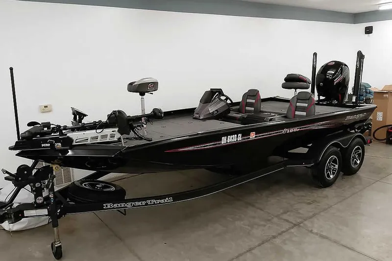 Slide: The Image of 2023 Ranger RT198P fishing boat in a garage, featuring dual seats and advanced equipment. - 42