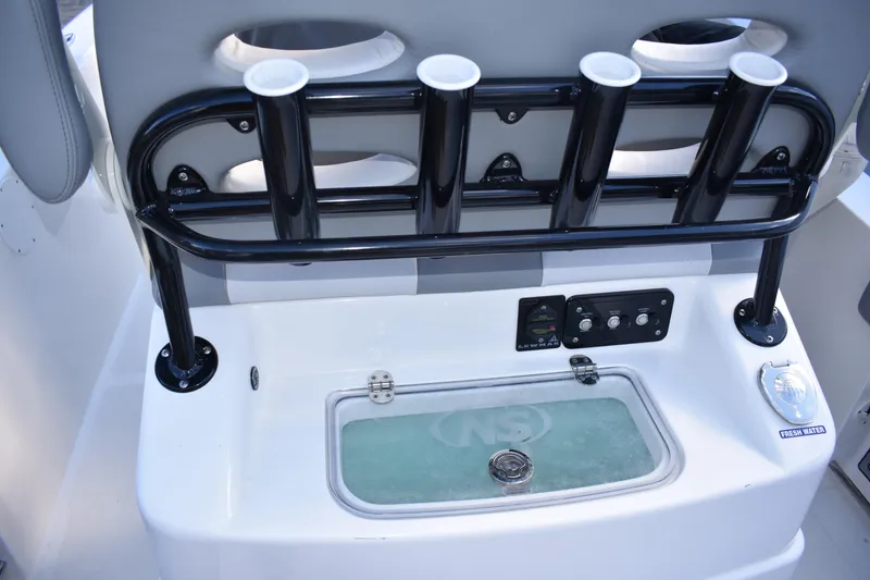 Slide: The Image of 2022 NauticStar 2602 Legacy boat console with rod holders and control panel. - 40