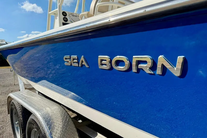 Slide: The Image of 2017 Sea Born FX24 Bay boat with blue hull and chrome lettering. - 8