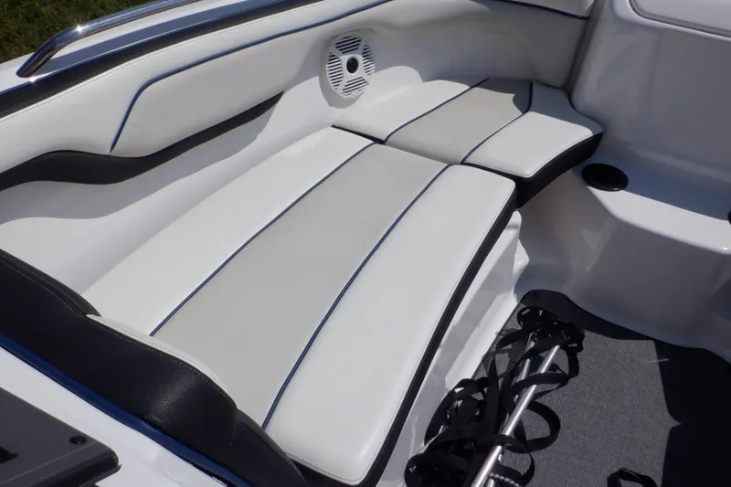 Slide: The Image of 2019 Yamaha Boats SX210 interior seating with white upholstery and speaker detail. - 11