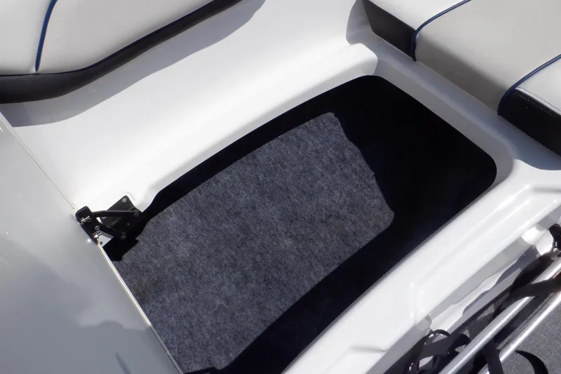 Slide: The Image of 2019 Yamaha SX210 boat storage compartment with cushioned seating and carpeted interior. - 19