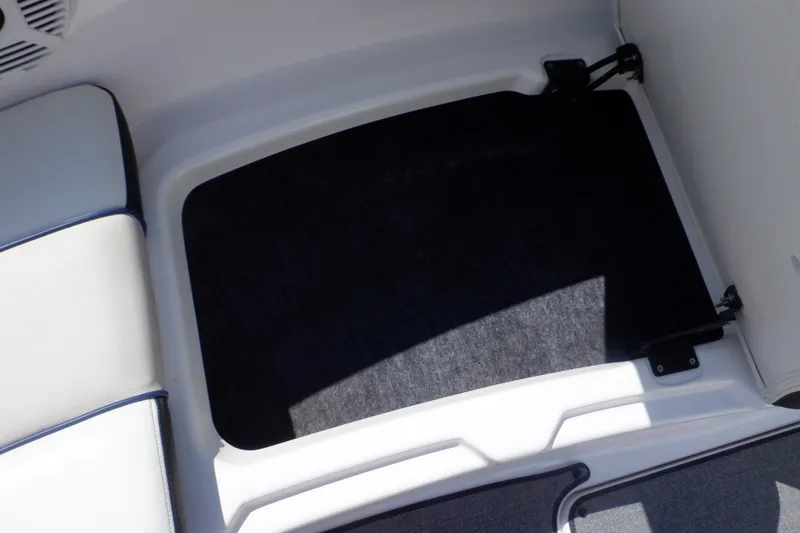 Slide: The Image of 2019 Yamaha SX210 boat storage compartment with black interior and white trim. - 20