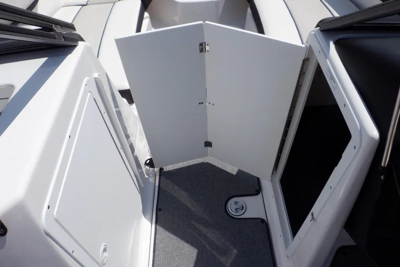Slide: The Image of 2019 Yamaha SX210 boat interior with open storage compartment and gray carpet flooring. - 29
