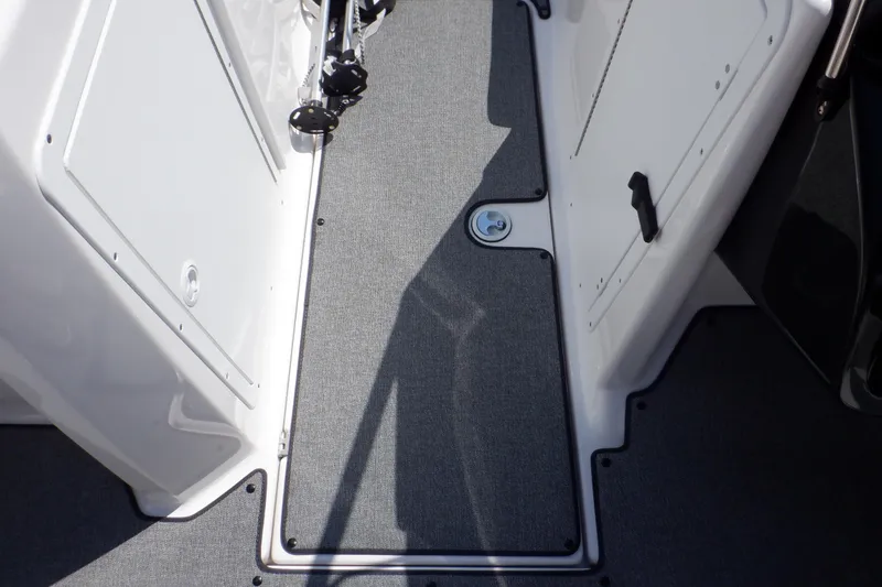 Slide: The Image of 2019 Yamaha Boats SX210 interior deck with gray carpet and storage compartments. - 30