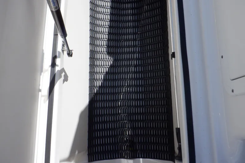 Slide: The Image of 2019 Yamaha SX210 boat interior with textured black flooring and hydraulic support. - 31