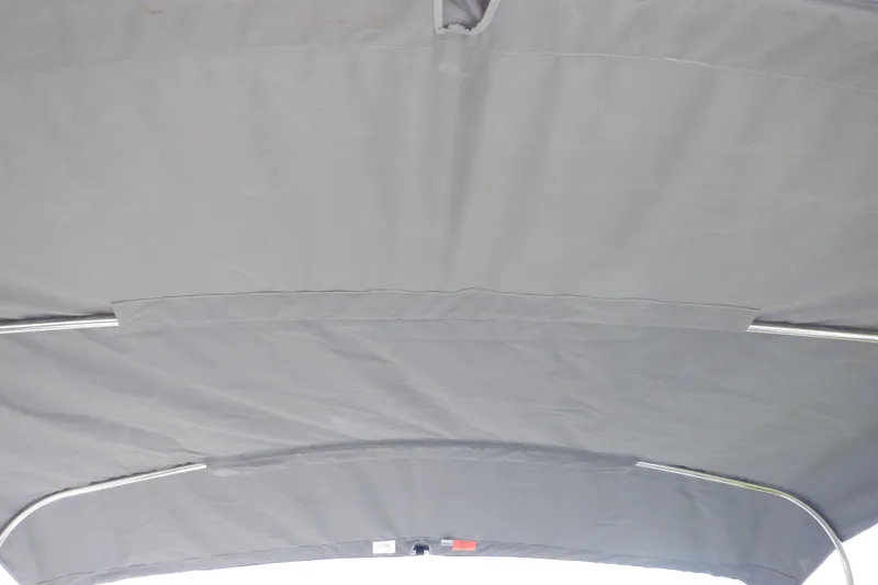 Slide: The Image of Gray canopy of a 2019 Yamaha SX210 boat, featuring metal support frames. - 49