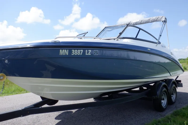 Slide: The Image of 2019 Yamaha Boats SX210 on trailer, blue and white, under clear sky. - 7