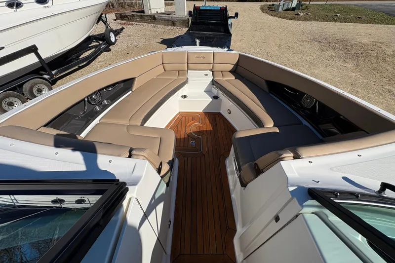 Slide: The Image of 2016 Sea Ray 350 SLX boat with tan seating and American flag, parked on gravel. - 20