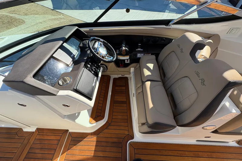 Slide: The Image of 2016 Sea Ray 350 SLX boat with tan seating and American flag, docked outdoors. - 21