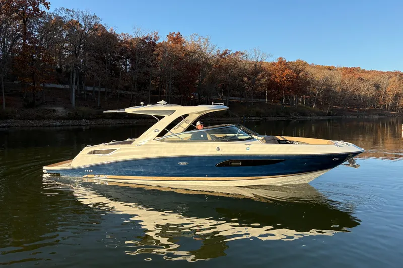 Slide: The Image of 2016 Sea Ray 350 SLX boat on trailer, parked outdoors under clear blue sky. - 3